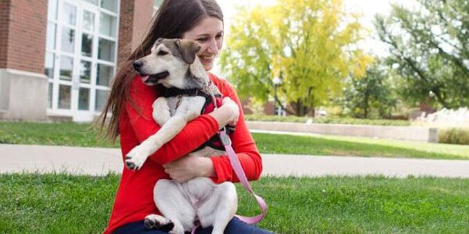 Student holding a dog