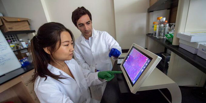 Two students working on a computer in a lab
